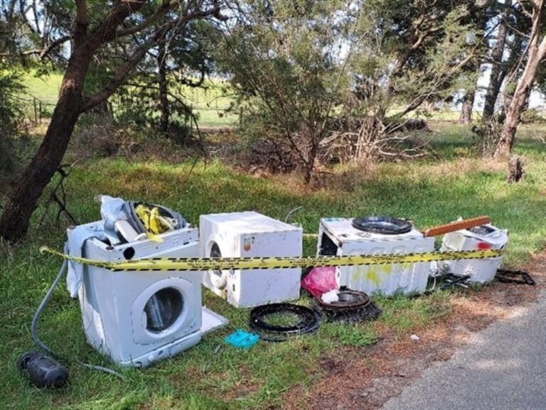 Dumped appliances in nature reserve, taped off area.