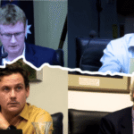 Men in a council meeting discussion.