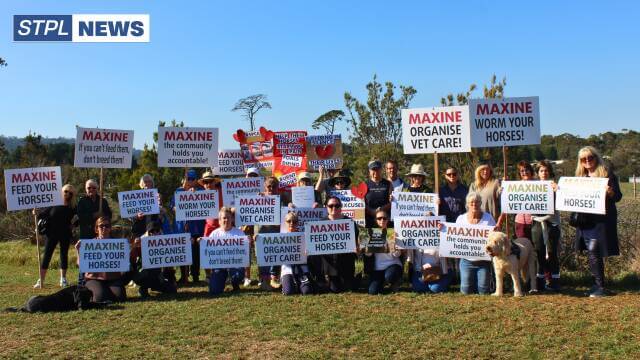 Group holding signs protesting horse care issues.