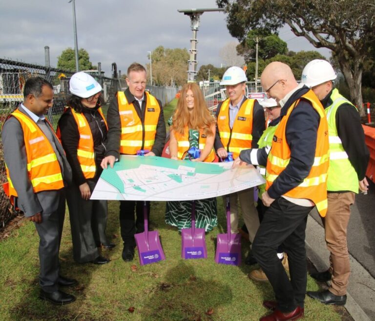 Group discusses construction plans with map outdoors.