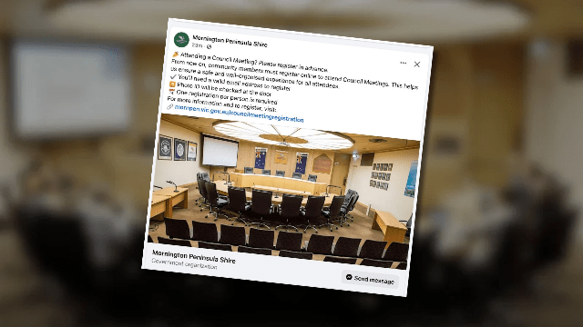 Council meeting room with chairs and screens.