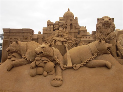 Detailed sand sculpture of chained bears and castle.