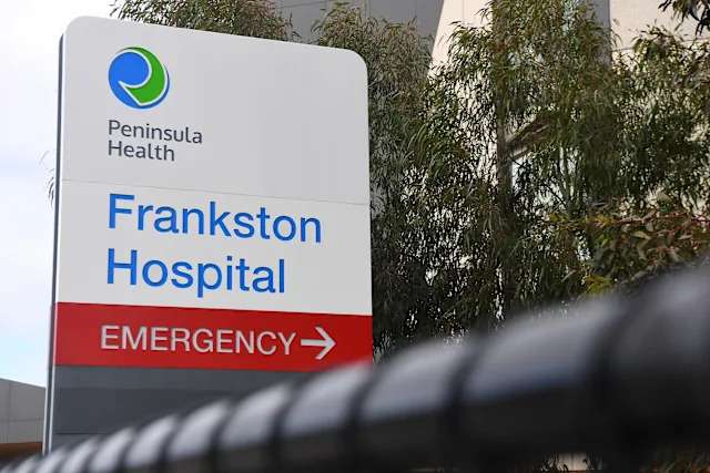 Frankston Hospital emergency sign with trees in background.