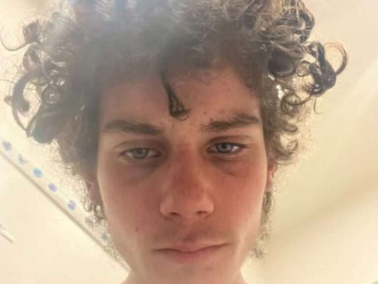 Person with curly hair looking down.