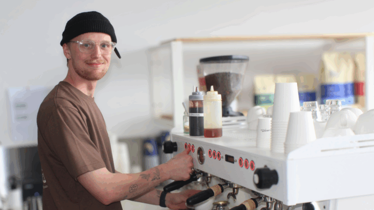 Barista making coffee in cafe with espresso machine.