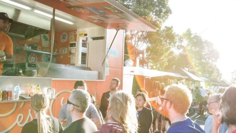 People gathering at a vibrant food truck festival.