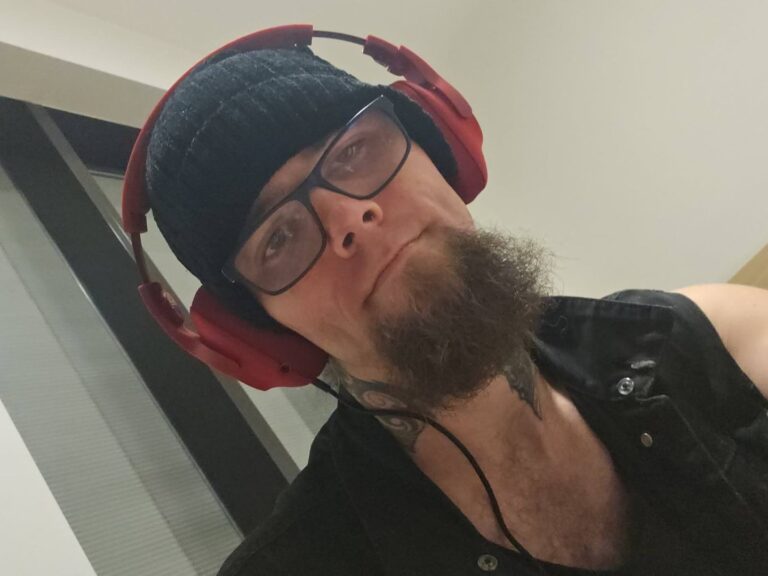 Man in beanie and headphones, indoor setting.