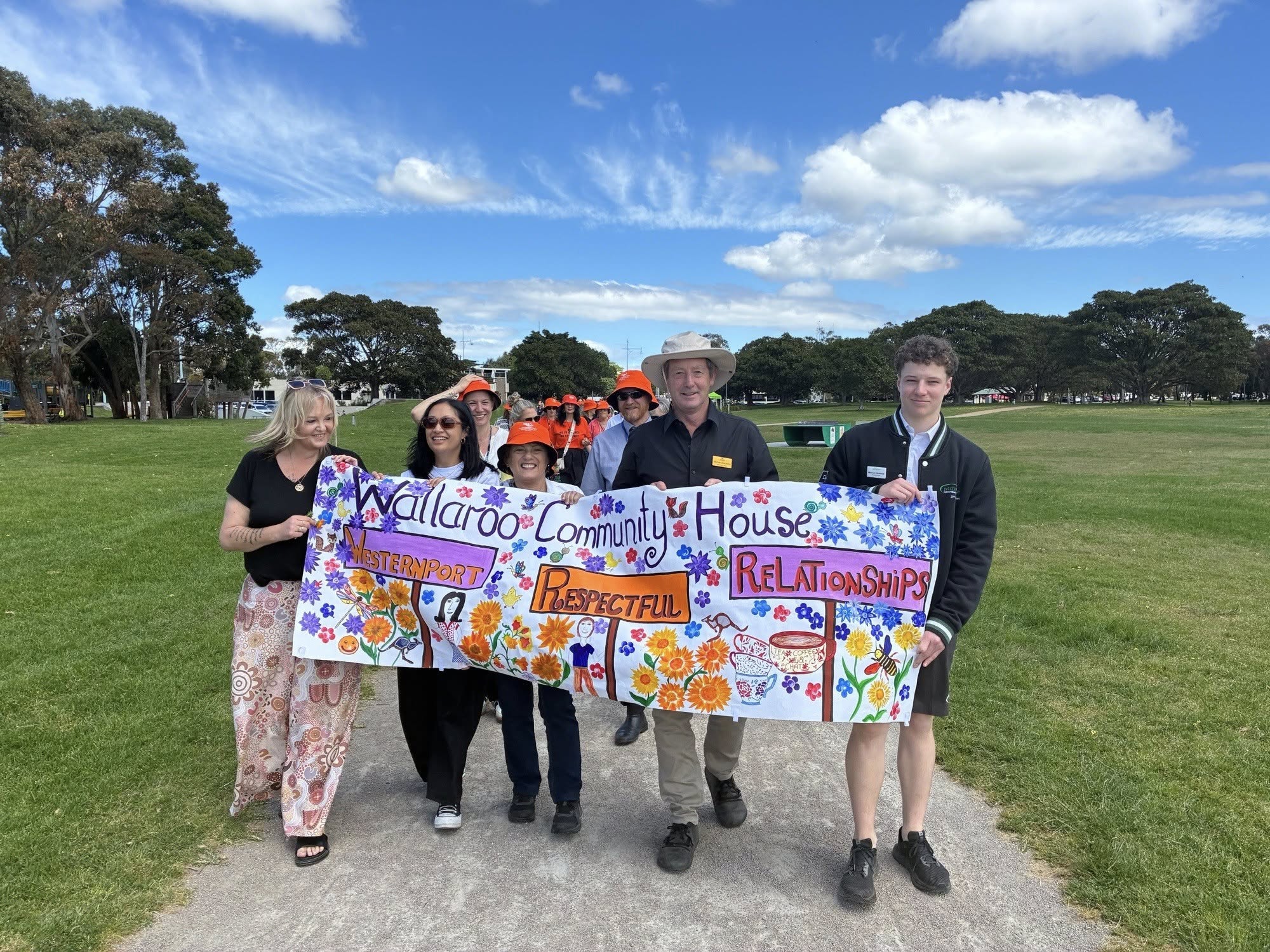 People holding vibrant Wallaroo Community House banner.