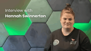 Interview with individual in dark shirt, green background.