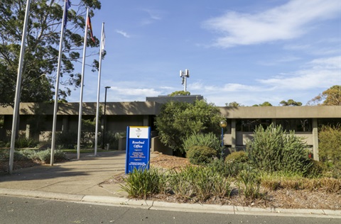 Front entrance of Radford college with sign and flags.