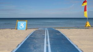 Accessible beach pathway with disability sign and flags.
