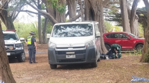 Police and coroner at crime scene.