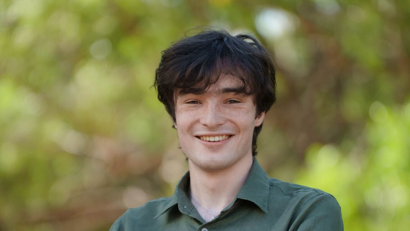 Isaac Willoughby, Greens candidate for Hastings, pictured outdoors in a green shirt.